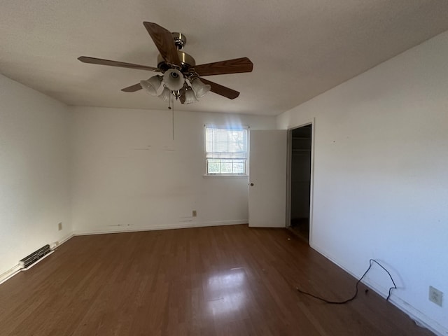 spare room with ceiling fan, dark wood-type flooring, and a textured ceiling