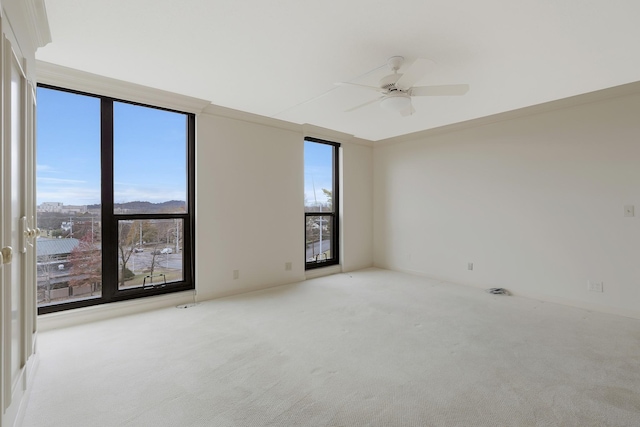 carpeted empty room featuring a mountain view and ceiling fan