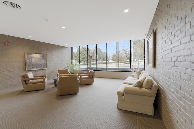 living room featuring carpet flooring, expansive windows, and brick wall