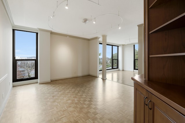 unfurnished room with light parquet flooring, a healthy amount of sunlight, and ornamental molding