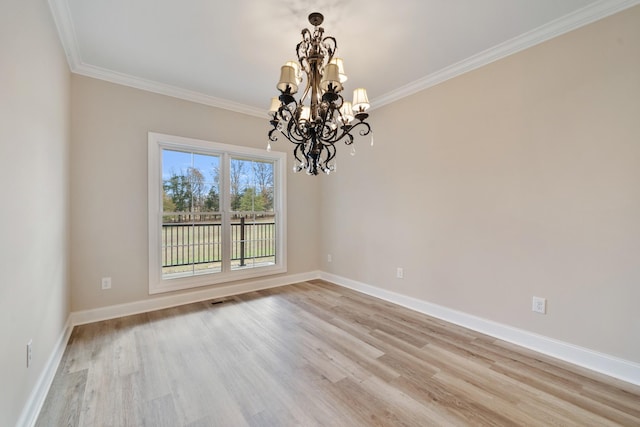 unfurnished room with light wood-type flooring, ornamental molding, and an inviting chandelier