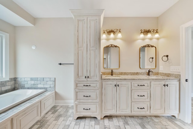 bathroom with a tub, vanity, and wood-type flooring