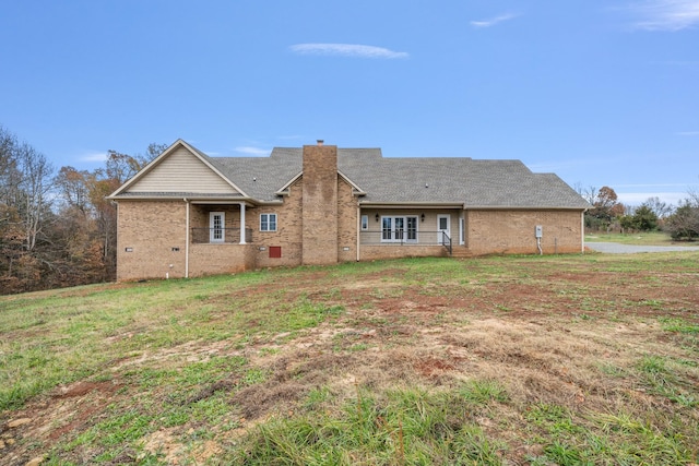 rear view of property featuring a lawn