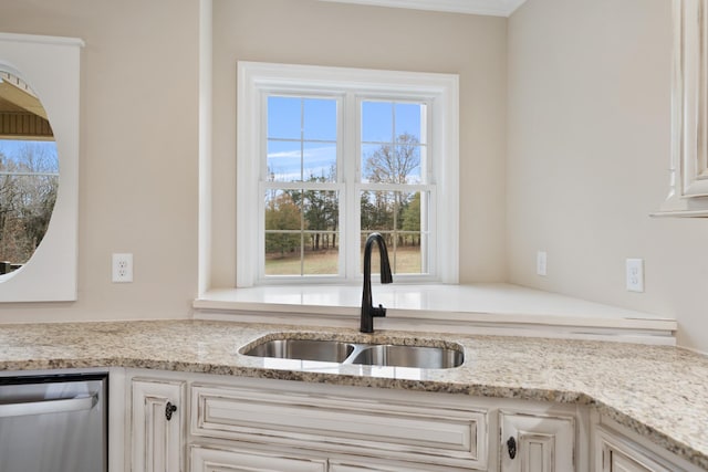 kitchen featuring dishwasher, white cabinetry, light stone countertops, and sink