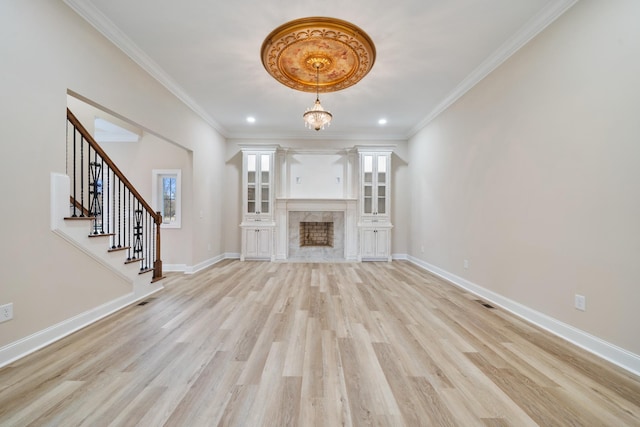 unfurnished living room with light hardwood / wood-style floors, a notable chandelier, and ornamental molding