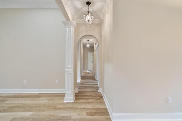 hall featuring crown molding, light hardwood / wood-style floors, and a notable chandelier