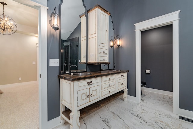 bathroom with a notable chandelier, vanity, and lofted ceiling