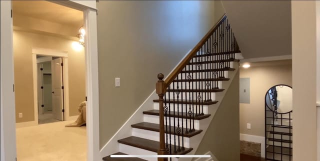 staircase with carpet floors and a notable chandelier