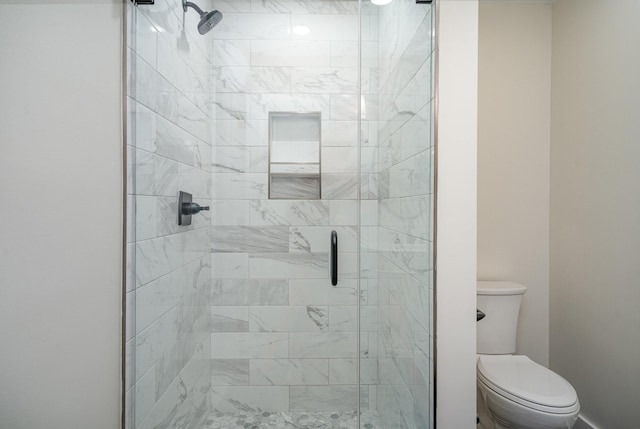 bathroom with an enclosed shower and toilet