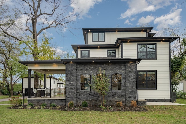 rear view of property featuring a lawn and cooling unit