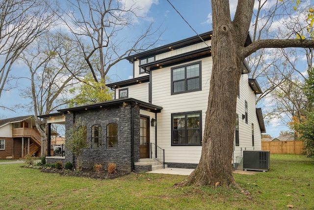 view of front of house featuring a patio area, cooling unit, and a front yard