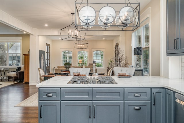 kitchen with light stone countertops, pendant lighting, dark hardwood / wood-style floors, and appliances with stainless steel finishes