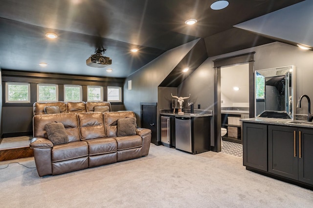 carpeted cinema with sink and vaulted ceiling