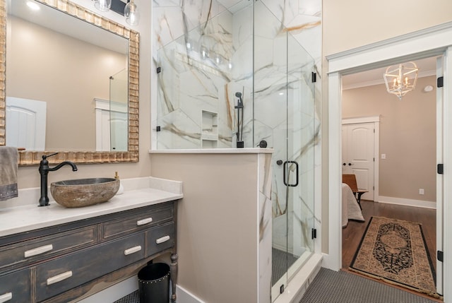 bathroom with vanity, ornamental molding, walk in shower, wood-type flooring, and a chandelier