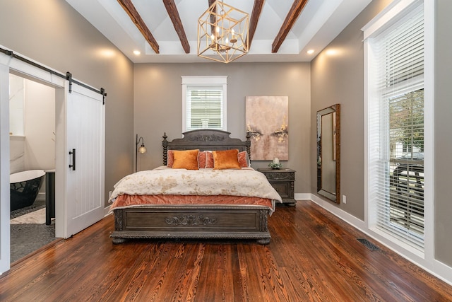 bedroom with beamed ceiling, a barn door, dark wood-type flooring, and an inviting chandelier