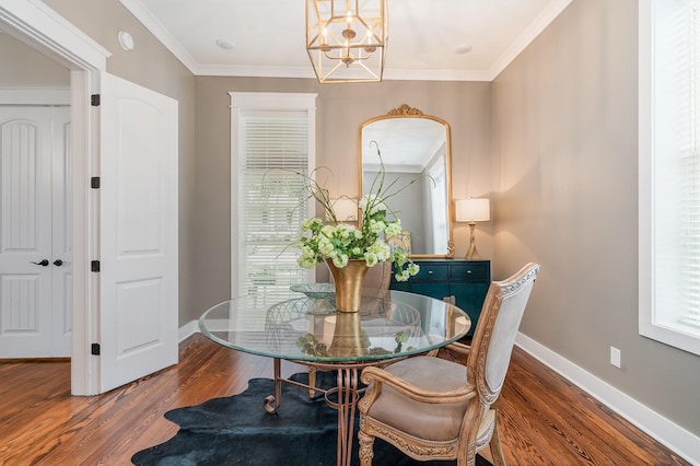 dining room with crown molding, wood-type flooring, and an inviting chandelier