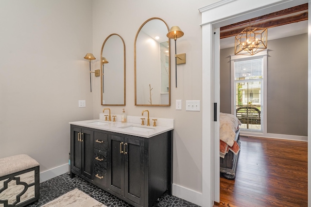 bathroom with beamed ceiling, vanity, wood-type flooring, and an inviting chandelier