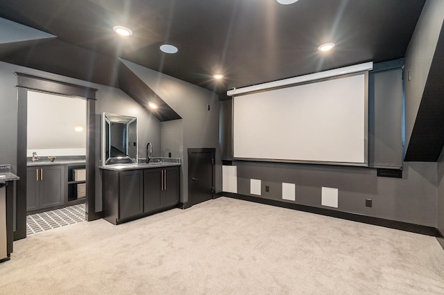 home theater with light colored carpet, sink, and vaulted ceiling