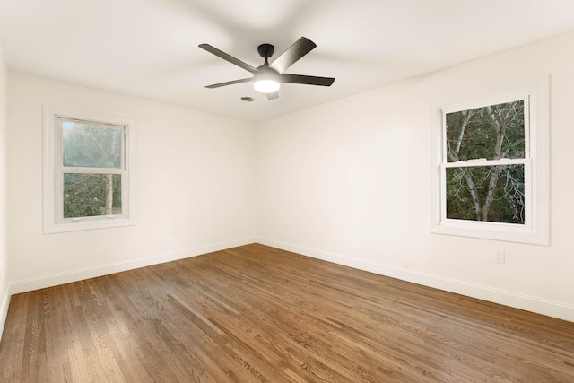 spare room featuring hardwood / wood-style flooring, ceiling fan, and a wealth of natural light