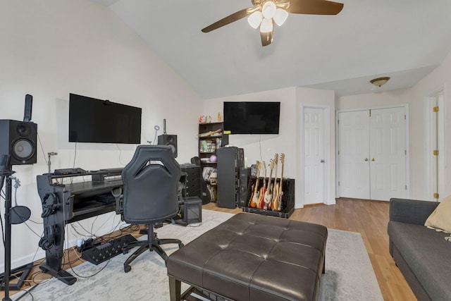 home office featuring ceiling fan, vaulted ceiling, and light hardwood / wood-style flooring