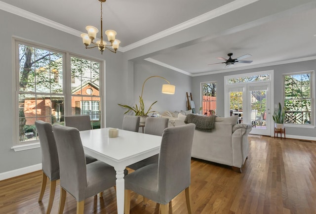 dining space with french doors, crown molding, dark hardwood / wood-style flooring, and ceiling fan with notable chandelier