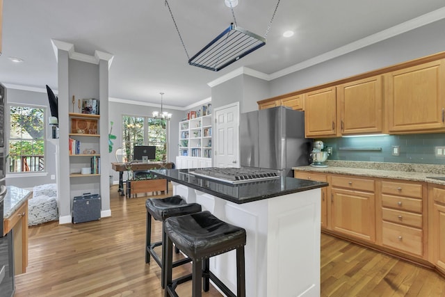 kitchen with stainless steel appliances, a chandelier, a kitchen island, and a healthy amount of sunlight