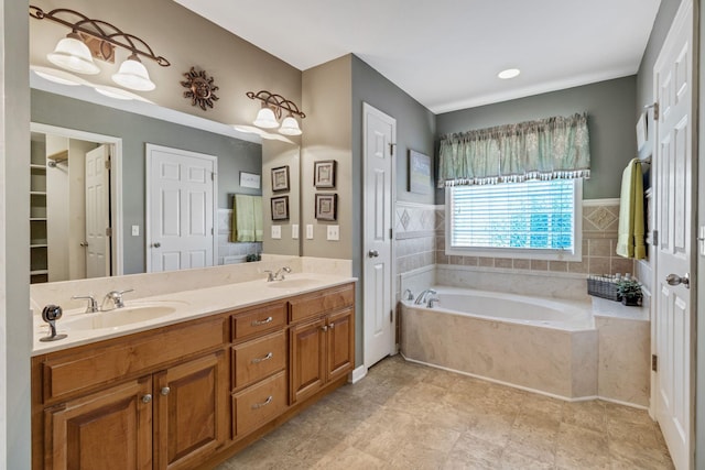 bathroom with vanity and a relaxing tiled tub