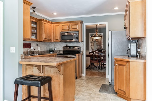 kitchen featuring sink, a breakfast bar, crown molding, and appliances with stainless steel finishes