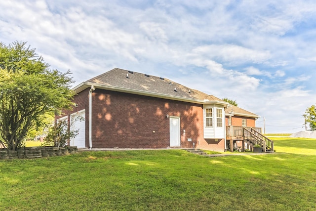 back of house featuring a lawn and a garage