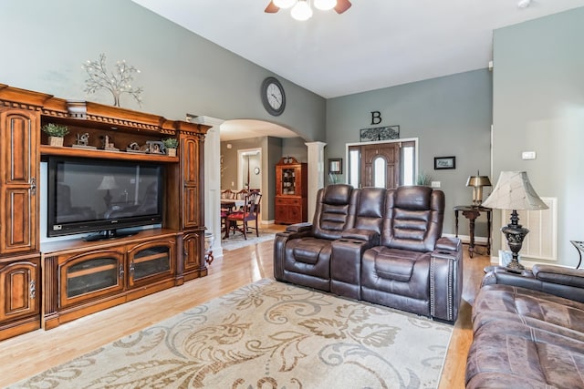 living room featuring light hardwood / wood-style floors, ornate columns, ceiling fan, and lofted ceiling