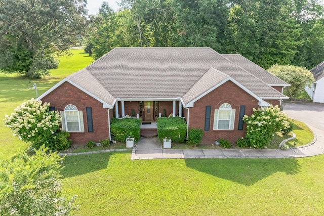 single story home featuring covered porch and a front lawn