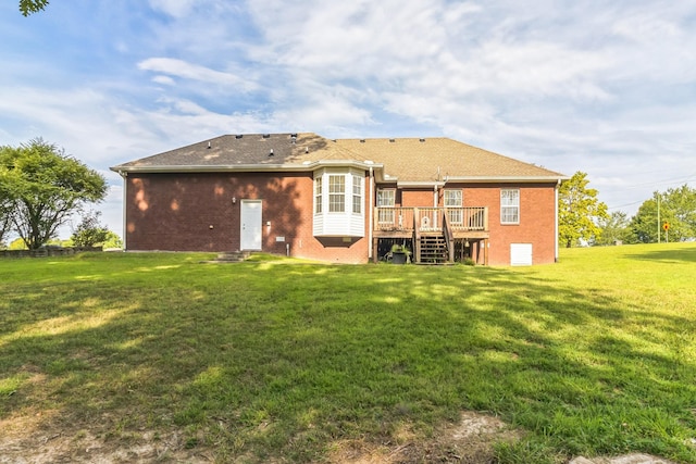 rear view of house with a wooden deck and a lawn