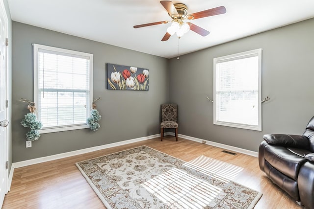 living area with ceiling fan and light wood-type flooring