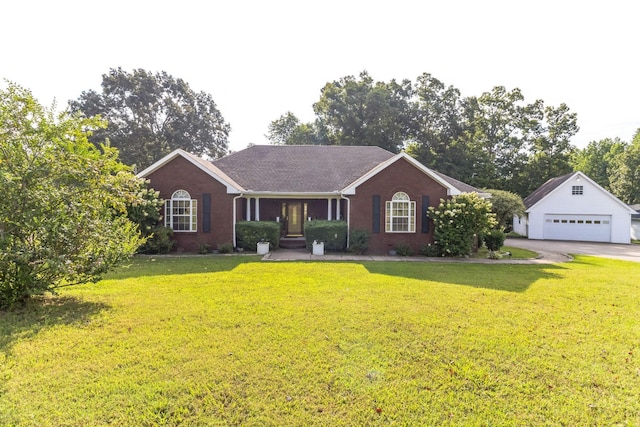 ranch-style home featuring an outbuilding, a garage, and a front yard