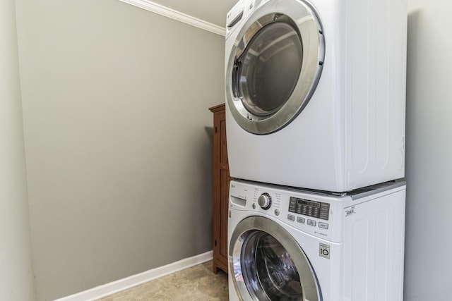 laundry room with stacked washer and dryer, cabinets, and ornamental molding