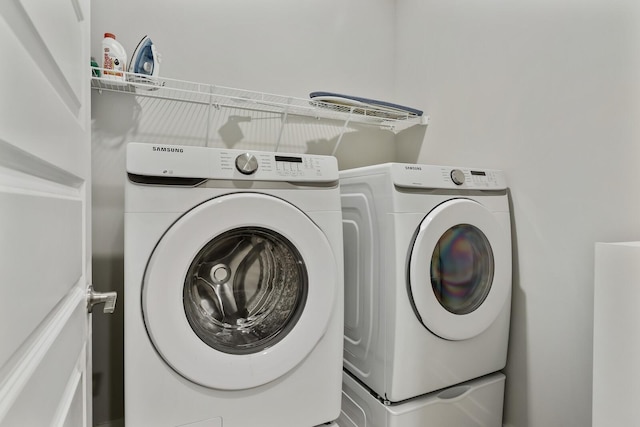 clothes washing area with washing machine and dryer