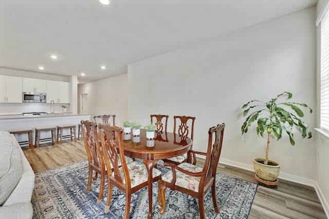 dining space featuring light wood-type flooring and sink