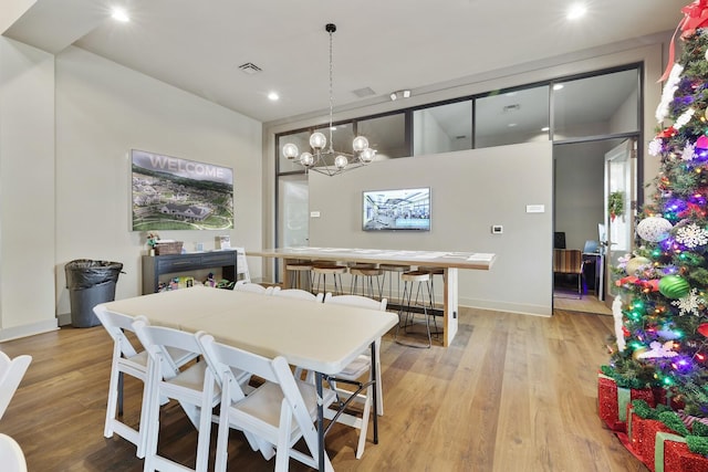 dining space featuring a notable chandelier and light wood-type flooring