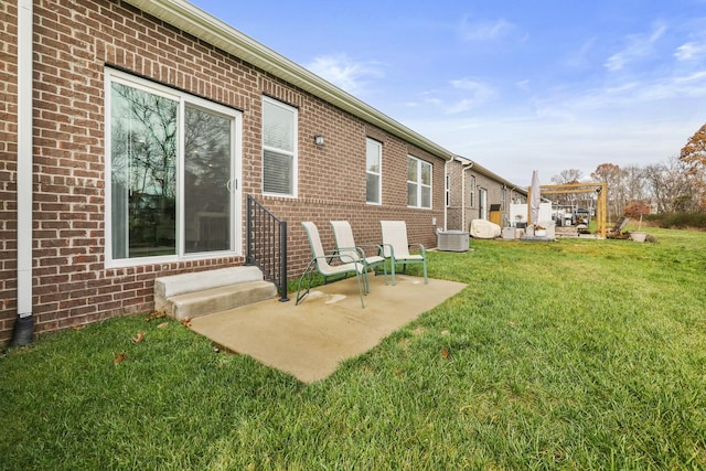 back of house featuring central air condition unit, a patio, and a yard