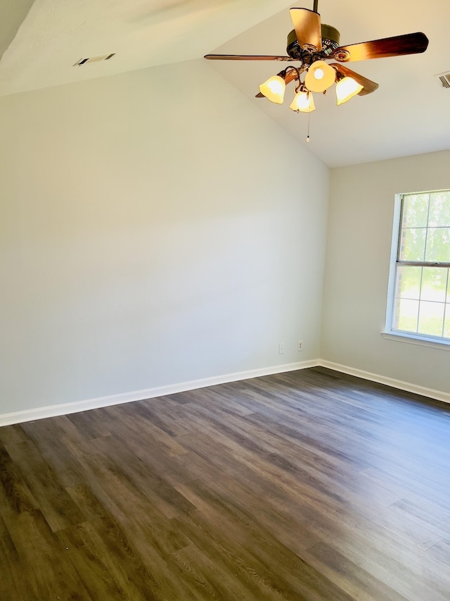 empty room with dark hardwood / wood-style floors, ceiling fan, and vaulted ceiling