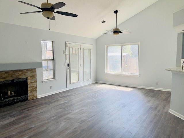 unfurnished living room featuring a stone fireplace, ceiling fan, dark hardwood / wood-style floors, and lofted ceiling