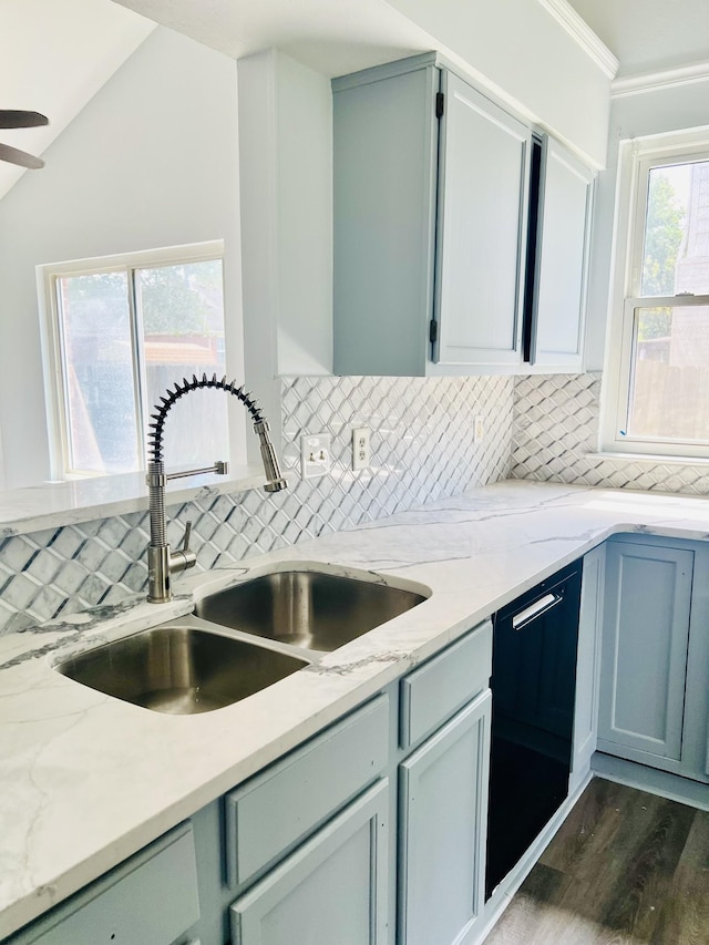 kitchen featuring decorative backsplash, a wealth of natural light, sink, and black dishwasher