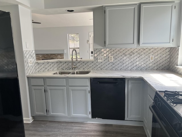 kitchen featuring black appliances, decorative backsplash, dark hardwood / wood-style flooring, and sink