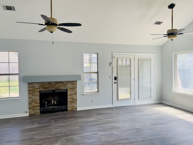 unfurnished living room with a wealth of natural light, vaulted ceiling, and hardwood / wood-style flooring