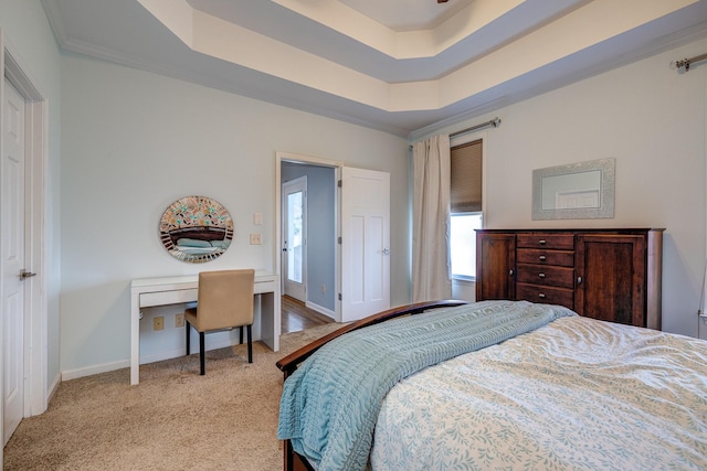 bedroom with light carpet, a tray ceiling, and crown molding