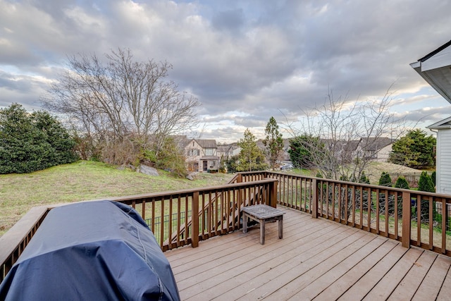 wooden terrace featuring a lawn and grilling area