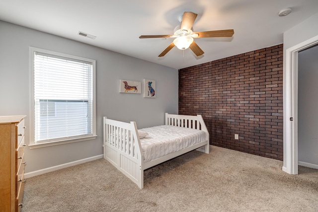 carpeted bedroom featuring ceiling fan and brick wall