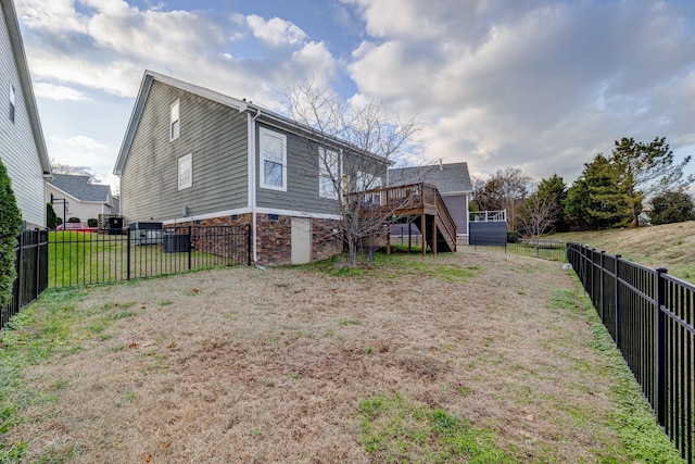 back of property featuring a lawn and a wooden deck