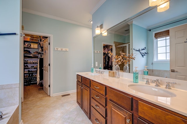 bathroom with tile patterned flooring, vanity, a shower with door, and crown molding