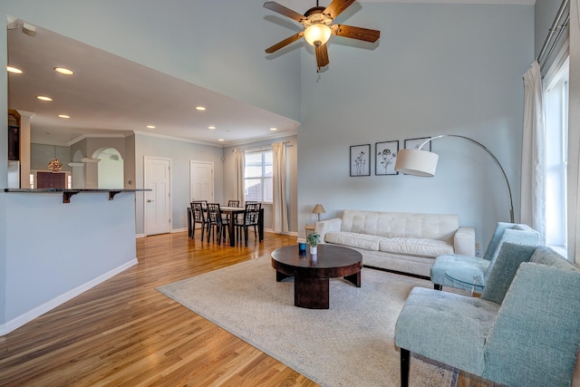 living room with ceiling fan, wood-type flooring, and ornamental molding